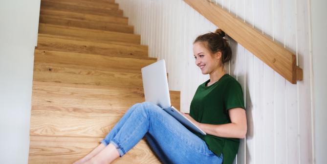 Seated woman on steps with a laptop 