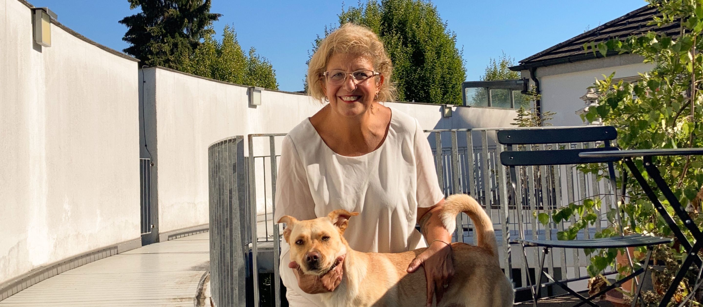 Una donna con un cane su una terrazza